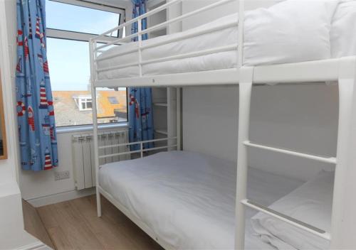 a bedroom with two bunk beds and a window at Atlantic Retreat 10a Ventnor Terrace in St Ives