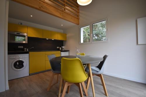 une cuisine avec une table et des chaises dans une cuisine dans l'établissement Maisonnette - Hossegor agréable maisonnette entre lac et océan, à Soorts-Hossegor