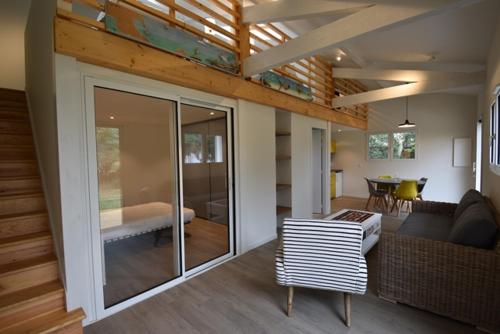 un salon avec un canapé et une salle à manger dans l'établissement Maisonnette - Hossegor agréable maisonnette entre lac et océan, à Soorts-Hossegor