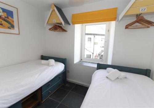two beds in a room with a window at 1 White Hart House The Wharf in St Ives
