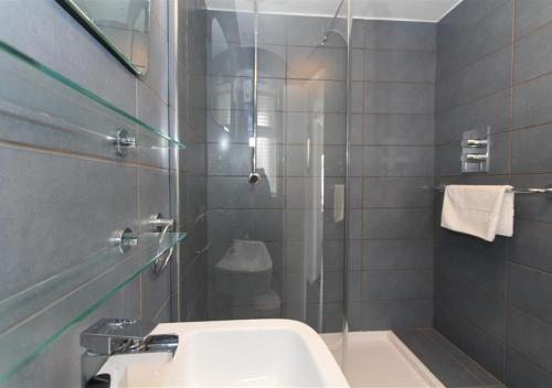 a bathroom with a sink and a glass shower at 1 White Hart House The Wharf in St Ives