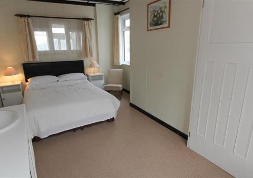 a bedroom with a white bed and a window at 4 Wharf House The Wharf in St Ives