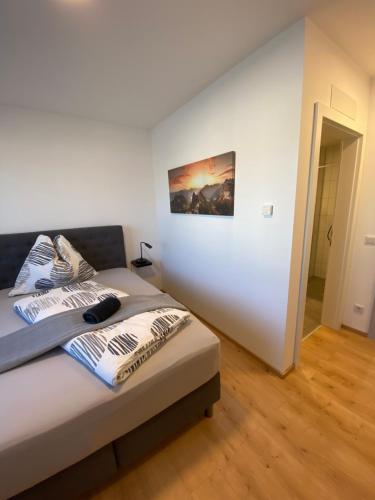 1 dormitorio con 1 cama con una pintura en la pared en To Be, en Sankt Andrä