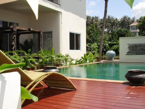 a house with a pool and a deck with a chair at Nakara Residence in Nathon