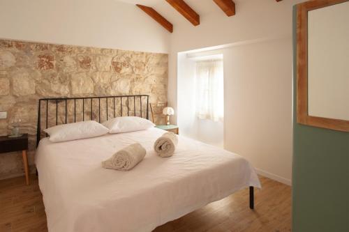 a bedroom with a white bed with towels on it at Sketches of Milna in Milna