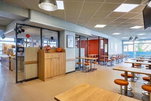 a dining room with tables and chairs and a cafeteria at ibis budget Paris Porte d'Aubervilliers in Aubervilliers