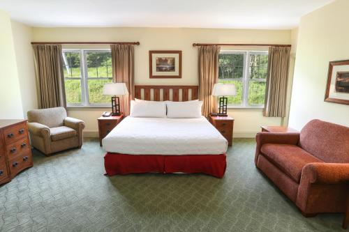 Kaatskill Mountain Club and Condos by Hunter Mountain في هونتر: غرفة نوم بسرير واريكة وكرسي