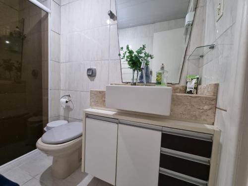 un bagno con lavandino, WC e specchio di Estúdio Beira Mar a Florianópolis