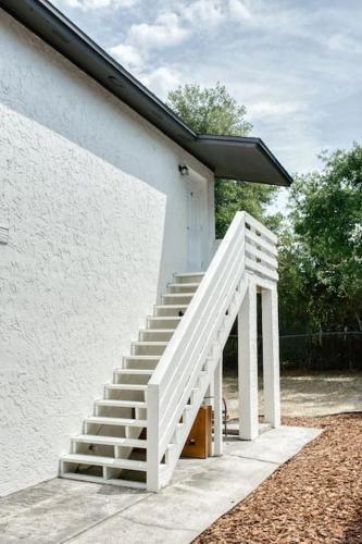 a white staircase next to a white building at Jay's Cozy Escape in Tampa