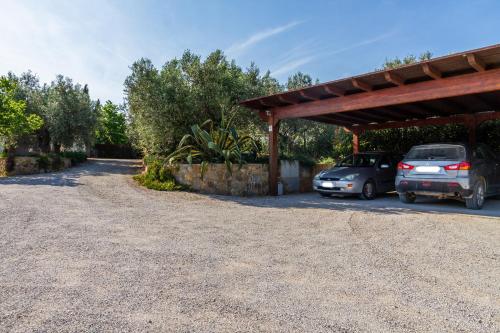 a parking lot with two cars parked under a roof at Villa Bouganville - Colleberto in Follonica