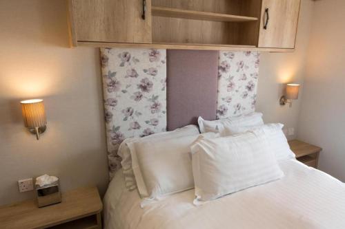 a bedroom with a bed with white sheets and pillows at Mallard Lake in South Cerney