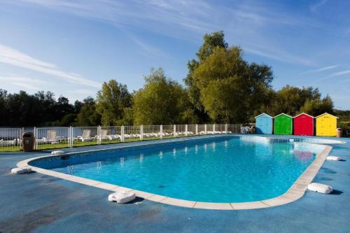 une grande piscine entourée de chaises dans l'établissement Mallard Lake, à South Cerney