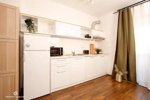 eine Küche mit weißen Schränken und einem Kühlschrank in der Unterkunft Cozy Concept Studio in Bukarest