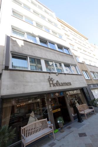 a building with a bench in front of a store at Hotel De Hofkamers in Ostend