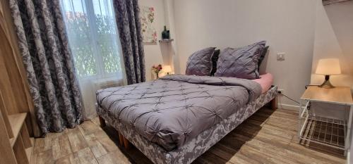 - une chambre avec un lit doté d'une couette violette et d'une fenêtre dans l'établissement Garden Carras, à Nice