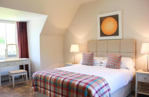 een slaapkamer met een bed met een geruite deken bij 4 bedroom holiday home with wheelchair accessible bathroom 2km from Kenmare in Kenmare
