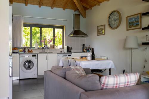 uma sala de estar com um sofá e uma mesa numa cozinha em The Pool House em Longos