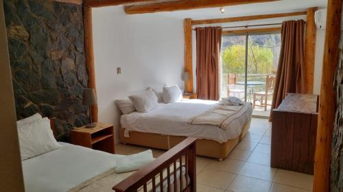 1 dormitorio con 2 camas y balcón en San Francisco Lodge & Spa, en Los Andes
