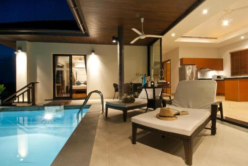 a living room with a swimming pool and a house at Villa Baan Saitara in Lamai