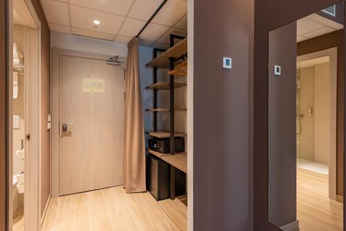 a room with a hallway with a door and a kitchen at Silken Puerta de Irati in Ochagavía