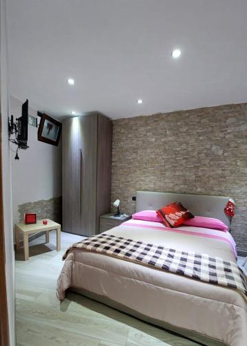 a bedroom with a large bed and a brick wall at b&b il pescatore in Castel di Sangro