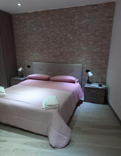 a bedroom with a large bed and a brick wall at b&b il pescatore in Castel di Sangro