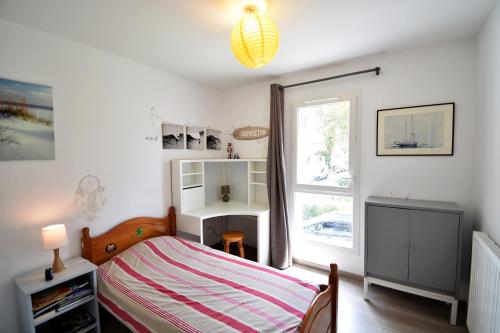 a bedroom with a bed and a desk and a window at Marensines - Capbreton jolie villa mitoyenne sur grand jardinet et terrasse en bois in Capbreton
