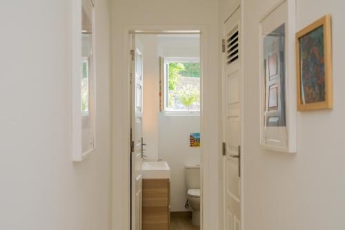 een witte badkamer met een toilet en een raam bij Cozy & Bright Lisbon-O campo na cidade in Lissabon