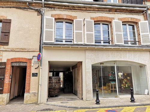 een oud gebouw met ramen en een winkelpui bij Au Terminus 15 Personnes in Hautvillers