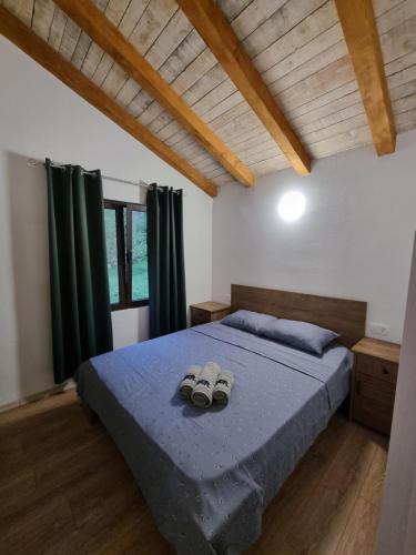 1 dormitorio con 1 cama con 2 zapatillas en Holiday Home Cattaro en Kotor
