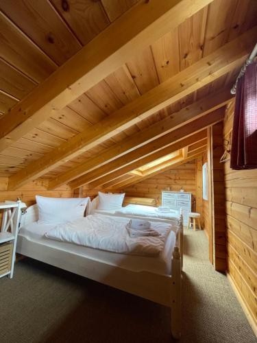 Bett in einem Zimmer mit Holzdecke in der Unterkunft Blockhaus an der Skiwiese Braunlage in Braunlage
