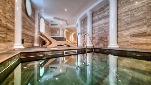 a swimming pool in a home with a stone wall at Hotel Plaza in Porto Azzurro