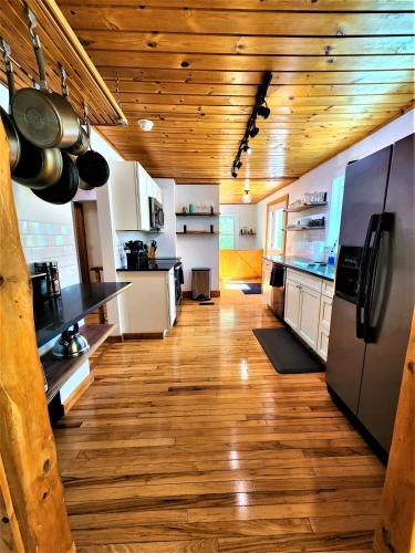a large kitchen with wooden floors and wooden ceilings at 3 Cottage Exclusive Retreat-Hot Tubs-Walk to Beach in Traverse City