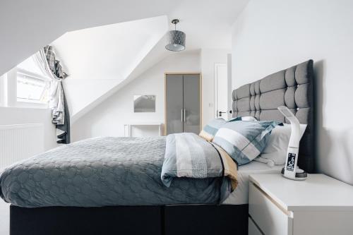 una camera con letto e testiera grigia di Luxury central apartment sleeps 7 guests with free parking and Netflix a Bournemouth
