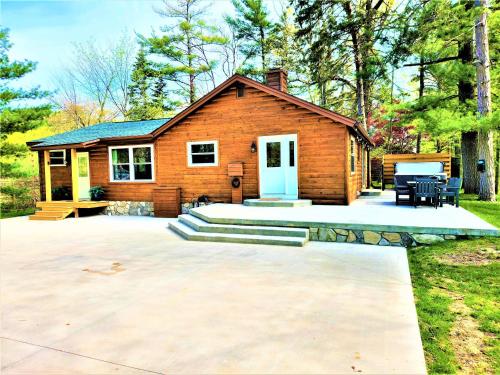 a log home with a patio and a house at 3 Cottage Exclusive Retreat-Hot Tubs-Walk to Beach in Traverse City