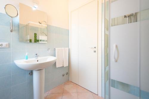 a white bathroom with a sink and a shower at Casa Mian - Bed and Breakfast in Orosei