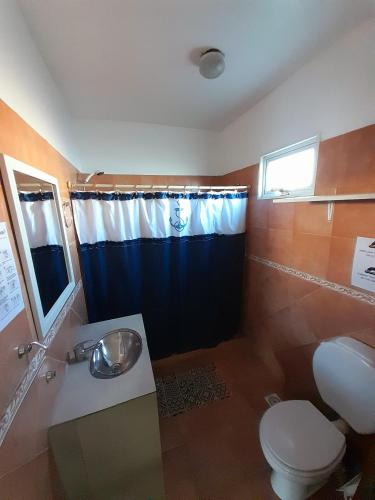 a bathroom with a toilet and a sink and a shower at El Atardecer in Puerto Pirámides