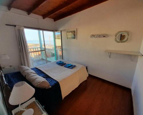 a bedroom with a bed and a balcony at El Atardecer in Puerto Pirámides