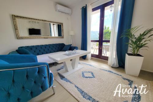 sala de estar con sofá azul y mesa en Apartmani Avanti Becici, en Bečići