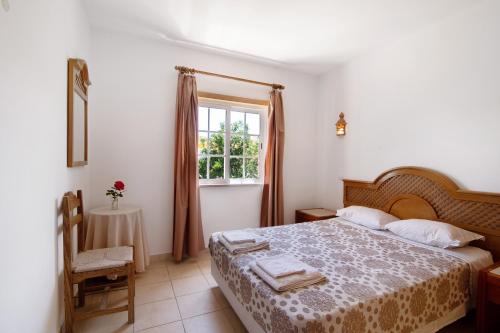 a bedroom with a large bed and a window at Algarve apartments L in Olhos de Água