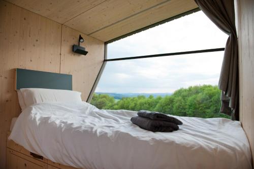 a bed in a room with a large window at Sleep Space 2 - Green Tiny Spot Dolmar 