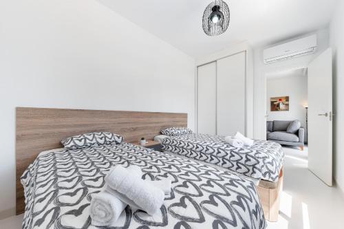 a white bedroom with two beds with pillows at Apartamento Los Alcores in San Miguel de Salinas