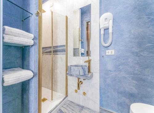 a bathroom with a shower with a glass door at Rivière Private Rooms Alla Scala in Milan