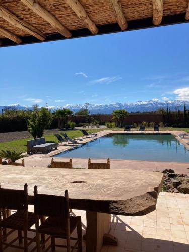 a large swimming pool with chairs and a table at Fellah Hotel in Marrakech