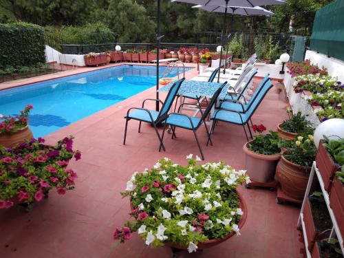 a patio with a table and chairs next to a swimming pool at Villa in Panorama, Thessaloniki, with a swimming pool. Host: Mr. George in Thessaloniki