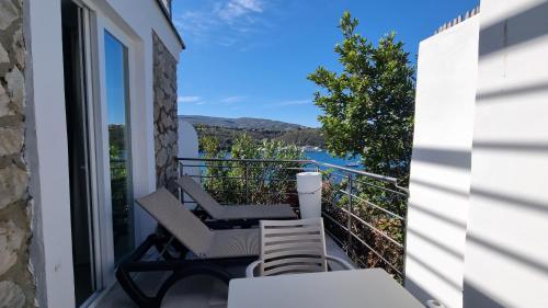a balcony with chairs and a view of the water at Hotel Plaza in Porto Azzurro