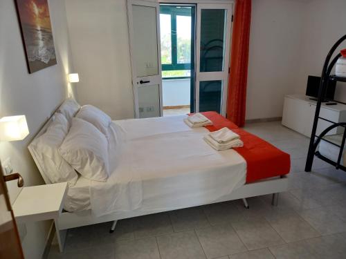 トッレ・サン・ジョヴァンニ・ウジェントにあるVilletta Sabbia d'Oroのベッドルーム(白いベッド1台、赤い毛布付)