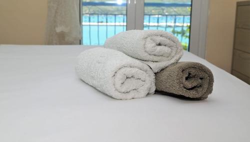 uma pilha de toalhas sentadas em cima de uma cama em Marianna Appartaments em Plataria