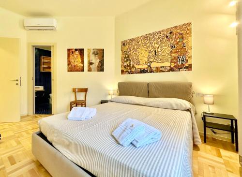 1 dormitorio con 1 cama con toallas en Hostdomus - Casa Corallo, en Alassio