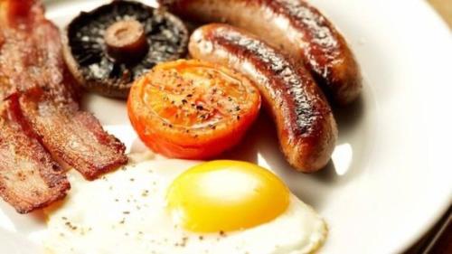 a plate of breakfast food with eggs bacon and sausage at The Acarsaid - Pitlochry in Pitlochry